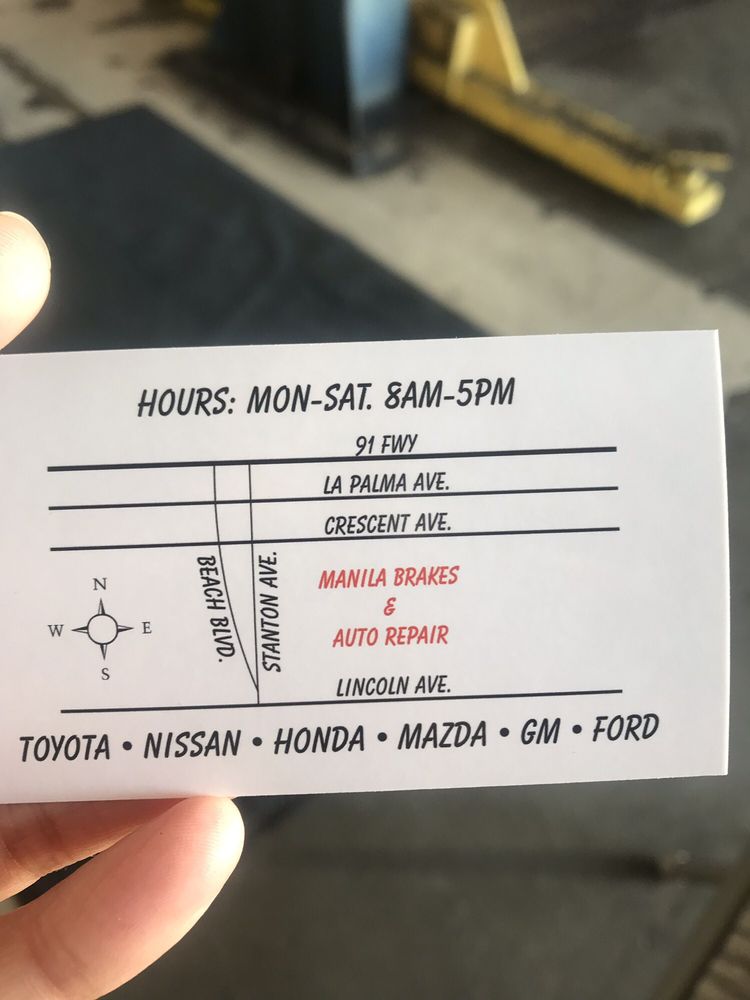 The shop's printed business card, showing a hand-drawn map with Manila Brakes & Auto Repair on Stanton Ave between Beach Blvd and Lincoln Ave, the hours Mon-Sat 8AM-5PM, and the makes serviced: Toyota, Nissan, Honda, Mazda, GM and Ford