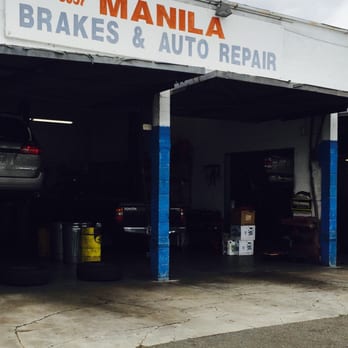 The open service bays beneath the Manila Brakes & Auto Repair sign, with a car on a lift inside