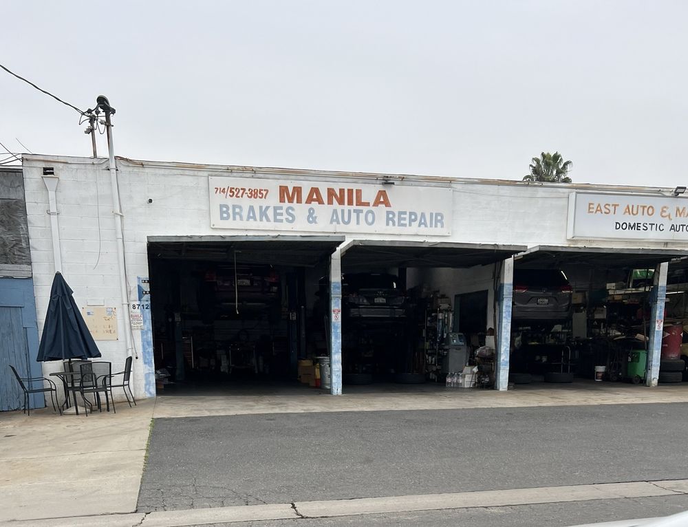 Manila Brakes & Auto Repair Inc. storefront with three open service bays on Stanton Ave in Buena Park